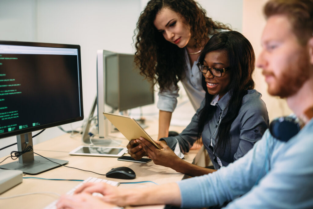 3 people working enthusiastically in an IT office