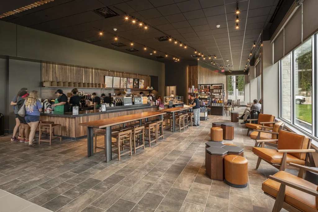 Modern interior of The Commons at UTA featuring a coffee shop, seating, and large windows.